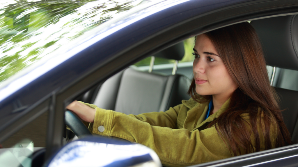 Young girl driving shows the importance of insurance for young drivers.