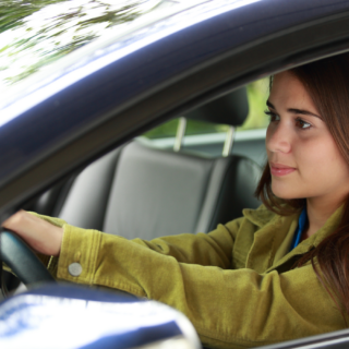 Young girl driving shows the importance of insurance for young drivers.