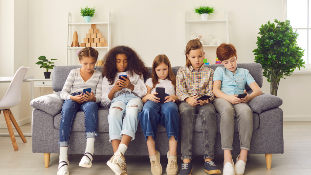 Children sitting o couch together all on phones showing the importance of cyber security for kids.